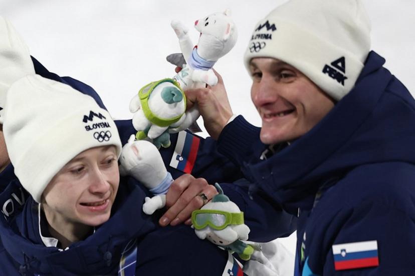 Slovenia's Nika Prevc (L) and Slovenia's Domen Prevc celebrate on the podium for the ski jumping mixed team final of the Milano Cortina 2026 Winter Olympic Games at Predazzo Ski Jumping Stadium in Predazzo (Val di Fiemme), on February 10, 2026.  Anne-Christine POUJOULAT / AFP