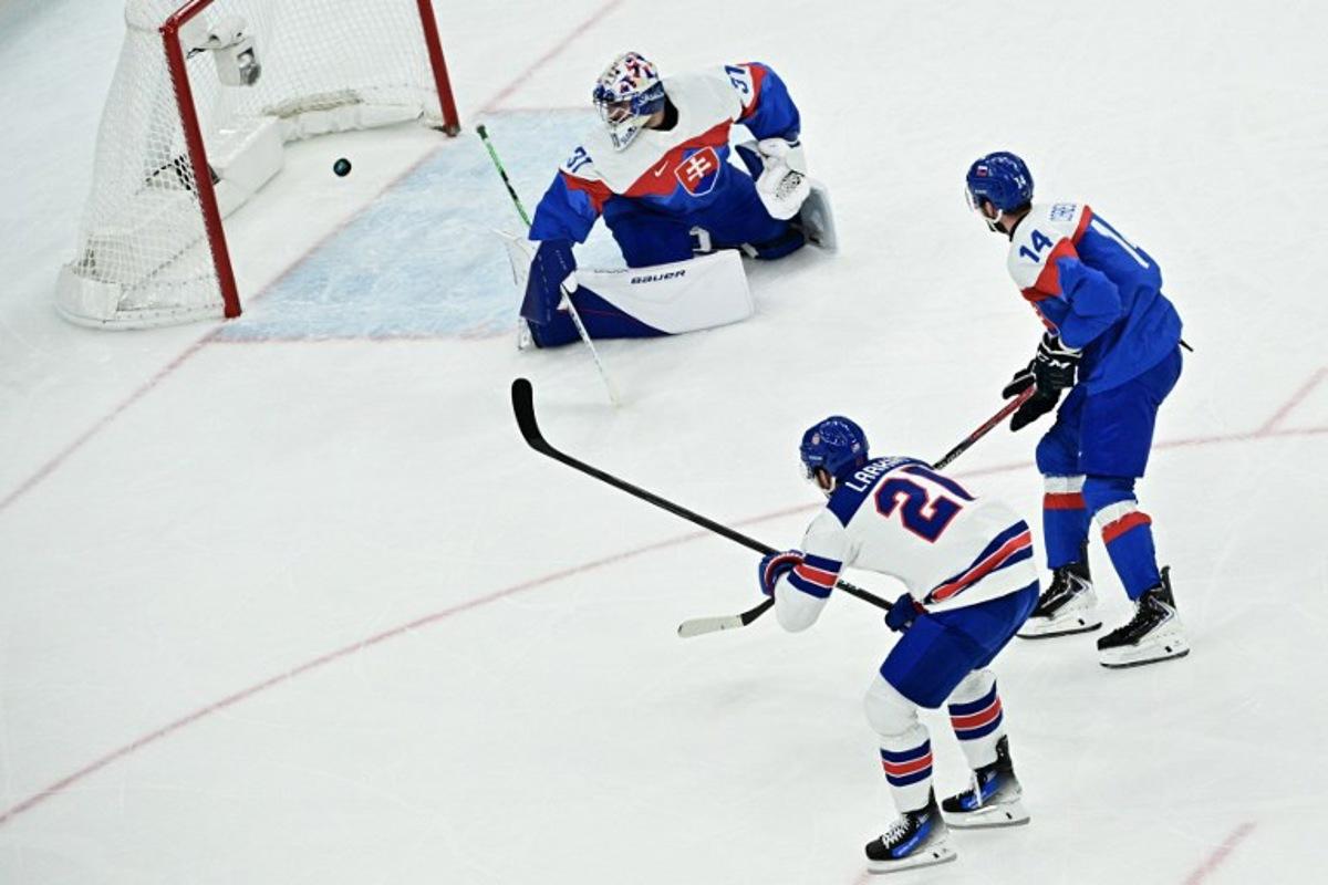 USA's #21 Dylan Larkin (L) scores their first goal past Slovakia's #31 Samuel Hlavaj during the men's play-off semi-final ice hockey match between USA and Slovakia at the Milano Santagiulia Ice Hockey Arena during the Milano Cortina 2026 Winter Olympic Games in Milan, on February 20, 2026.  JULIEN DE ROSA / AFP