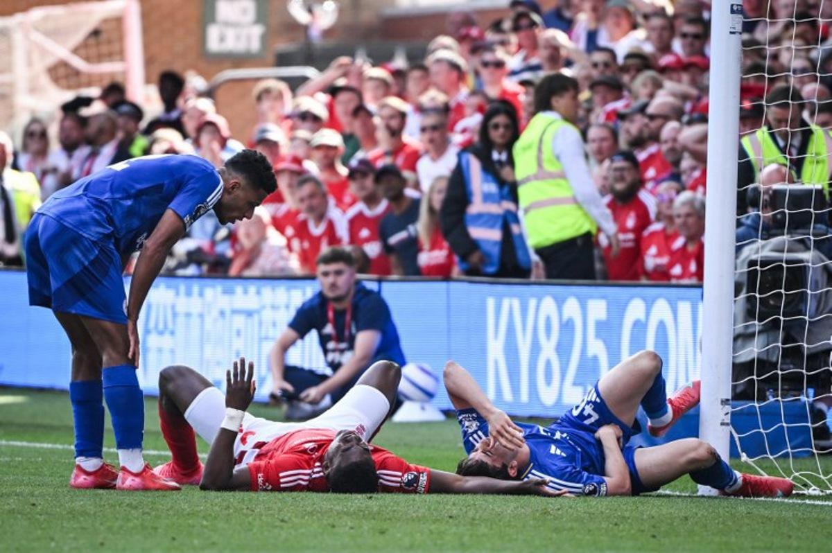Nottingham Forest's Nigerian striker #09 Taiwo Awoniyi (C) and Leicester City's Argentinian midfielder #40 Facundo Buonanotte (R) react after colliding during the English Premier League football match between Nottingham Forest and Leicester City at The City Ground in Nottingham, central England, on May 11, 2025.  JUSTIN TALLIS / AFP