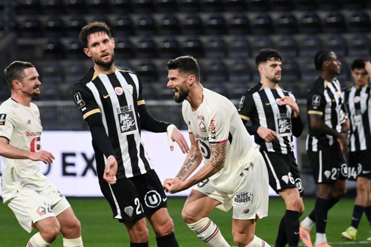 Lille's French forward #09 Olivier Giroud (C) celebrates scoring his team's first goal from the penalty spot during the French L1 football match between SCO Angers and Lille LOSC at the Raymond-Kopa Stadium in Angers, western France, on February 22, 2026.  JEAN-FRANCOIS MONIER / AFP
