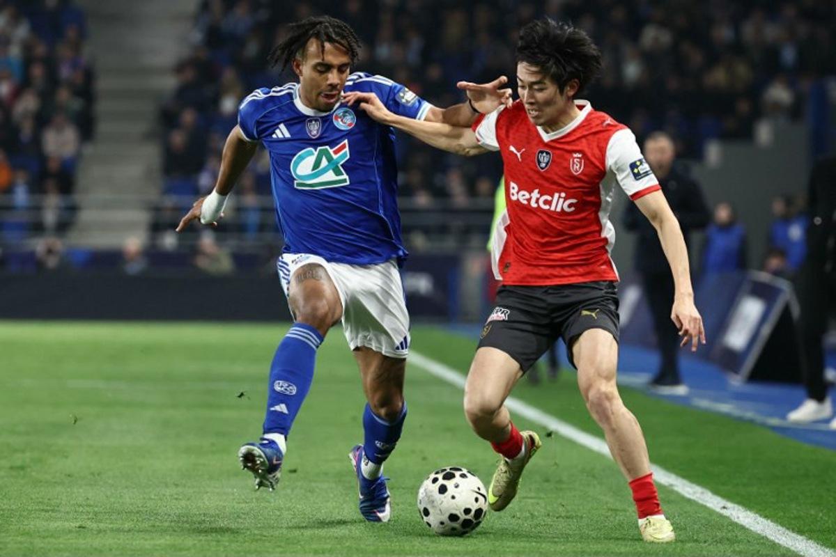 Strasbourg's Ivorian defender #22 Guela Doue (L) fights for the ball with Reims' Japanese forward #17 Keito Nakamura during the French Cup quarter final football match between RC Strasbourg Alsace and Stade de Reims at the Stade de la Meinau in Strasbourg, eastern France, on March 3, 2026.  Frederick FLORIN / AFP