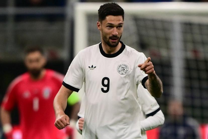 Germany's forward #09 Tim Kleindienst celebrates after scoring his team's first goal during the Nations League quarter final first leg football match between Italy and Germany at the San Siro Stadium in Milan, on March 20, 2025.  Marco BERTORELLO / AFP