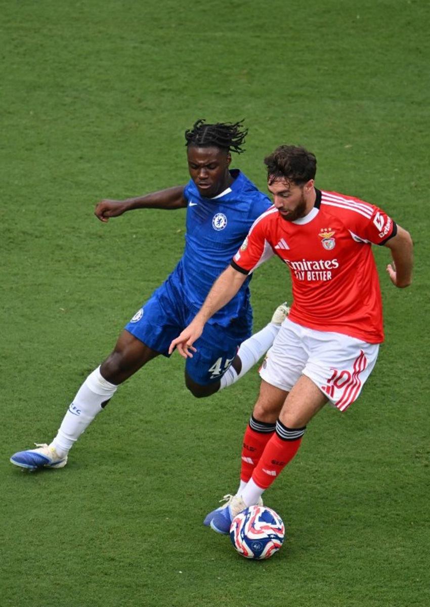 Chelsea's Belgian midfielder #45 Romeo Lavia and Benfica's Turkish midfielder #10 Orkun Kokcu fight for the ball during the FIFA Club World Cup 2025 round of 16 football match between Portugal's Benfica and England's Chelsea at the Bank of America Stadium in Charlotte on June 28, 2025.  ANGELA WEISS / AFP