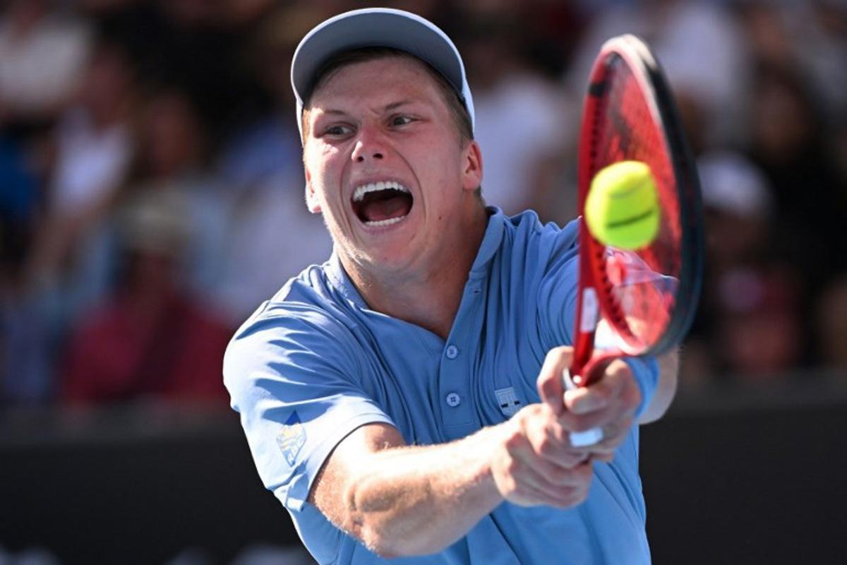 USA's Jenson Brooksby hits a return against USA's Tommy Paul during their men's singles match on day six of the Australian Open tennis tournament in Melbourne on January 21, 2023.  WILLIAM WEST / AFP