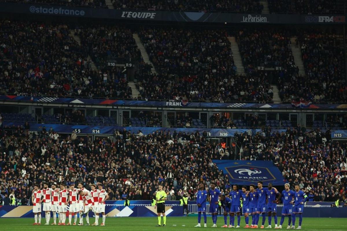 Croatia's players (L) and France's players (R) stand as they watch the penalty shoot-out during the UEFA Nations League quarter-final second-leg football match between France and Croatia at the Stade de France in Saint-Denis, north of Paris, on March 23, 2025.  FRANCK FIFE / AFP
