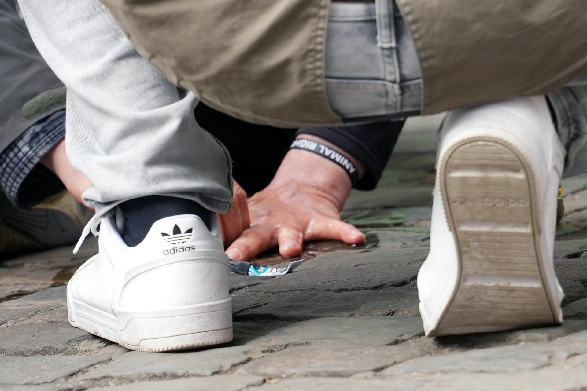 Wouter Mouton, climate activist of Extinction Rebellion, glued his hand to the street, a protest action at the Gravensteen monument in Gent on Wednesday 16 April 2025. BELGA PHOTO JONAS D'HOLLANDER