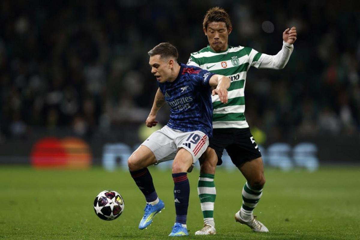 Arsenal's Belgian midfielder #19 Leandro Trossard and Sporting Lisbon's Japanese midfielder #05 Hidemasa Morita fight for the ball during the UEFA Champions League quarter final first leg football match between Sporting CP and Arsenal at Jose Alvalade stadium in Lisbon on April 7, 2026.  FILIPE AMORIM / AFP