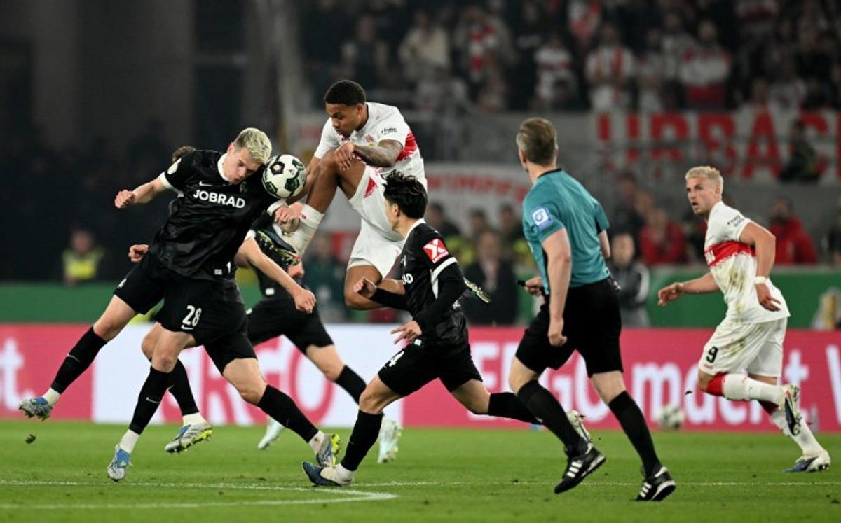Stuttgart's Danish midfielder #28 Nikolas Nartey (top) and Freiburg's German defender #28 Matthias Ginter (L) vie for the ball during the German Cup (DFB-Pokal) semi-final football match between VfB Stuttgart and FC Freiburg in Stuttgart, southwestern Germany, on April 23, 2026.  THOMAS KIENZLE / AFP