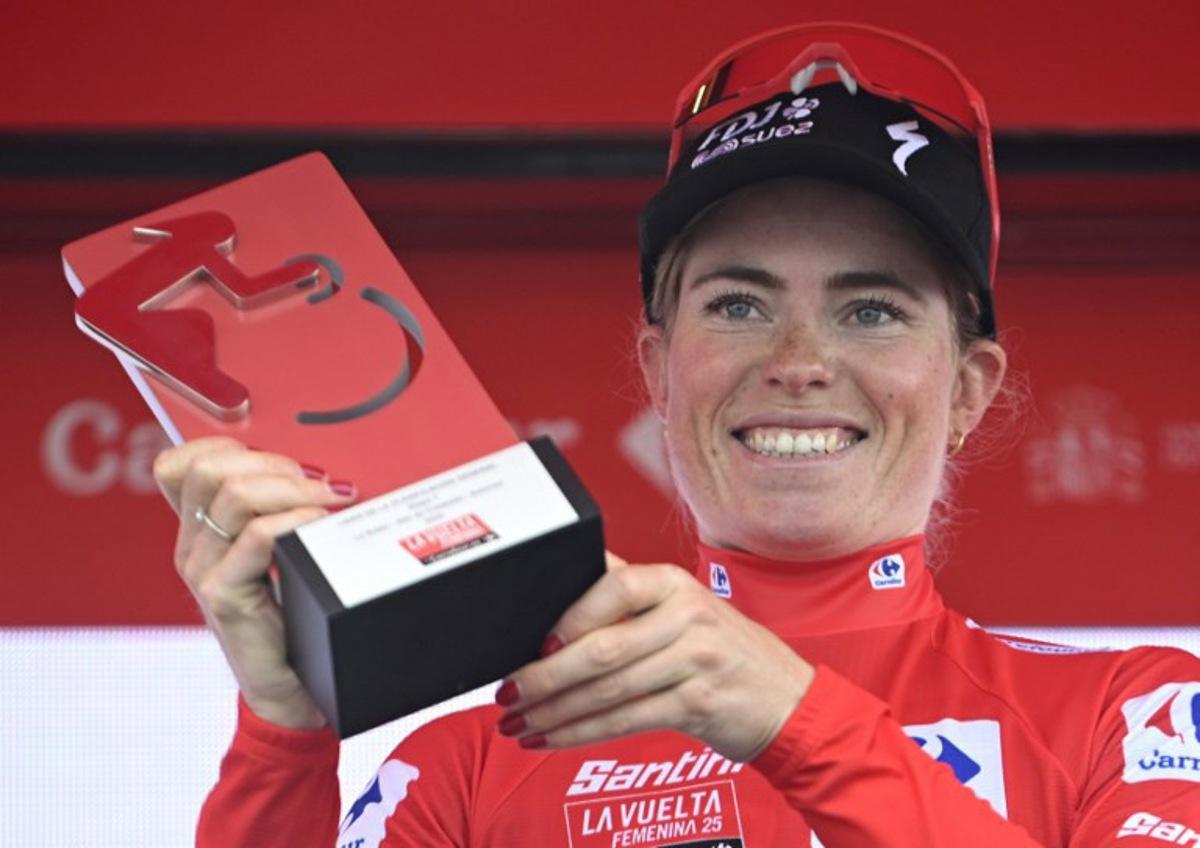 Overall leader FDJ-Suez team's Dutch rider Demi Vollering wearing the red jersey celebrates on the podium after the 7th stage of the 2025 La Vuelta Femenina cycling tour of Spain, a 152.6 km race from La Robla to Cotobello, on May 10, 2025.  MIGUEL RIOPA / AFP