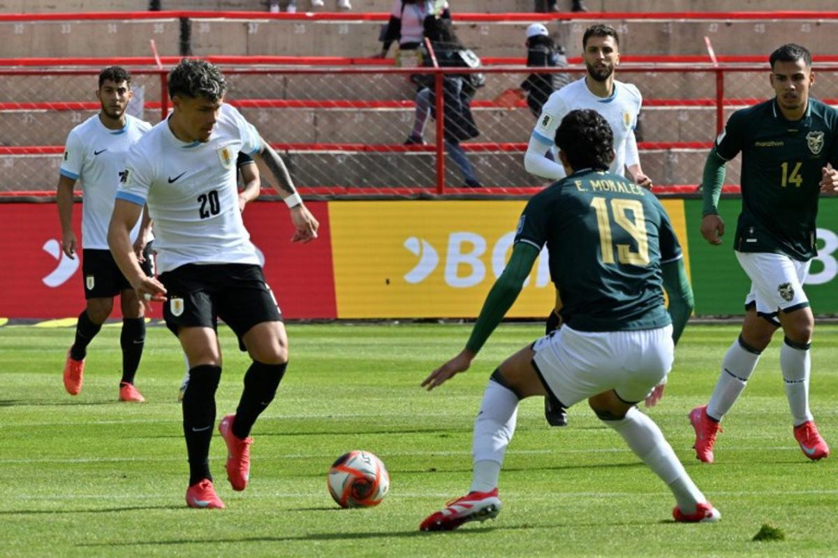 Uruguay's midfielder #20 Maximiliano Araujo and Bolivia's defender #19 Efrain Morales fight for the ball during the 2026 FIFA World Cup South American qualifiers football match between Bolivia and Uruguay at the Municipal de El Alto stadium in El Alto, Bolivia, on March 25, 2025.  AIZAR RALDES / AFP