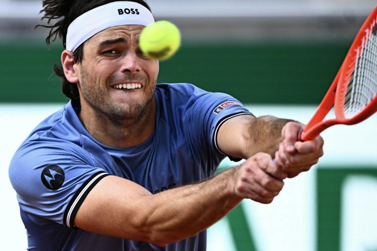 US Taylor Fritz plays a backhand return to US Nishesh Basavareddy during their men's singles match on day 1 of the French Open tennis tournament on Court Suzanne-Lenglen at the Roland-Garros Complex in Paris on May 24, 2026.  JULIEN DE ROSA / AFP
