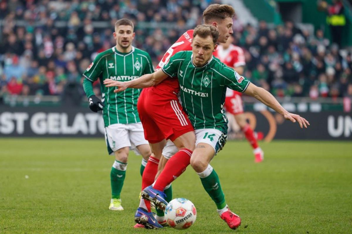 Bremen's Belgian midfielder #14 Senne Lynen and Bayern Munich's German midfielder #06 Joshua Kimmich vie for the ball during the German first division Bundesliga football match between SV Werder Bremen and FC Bayern Munich in Bremen, northern Germany February 14, 2026.   Focke Strangmann / AFP