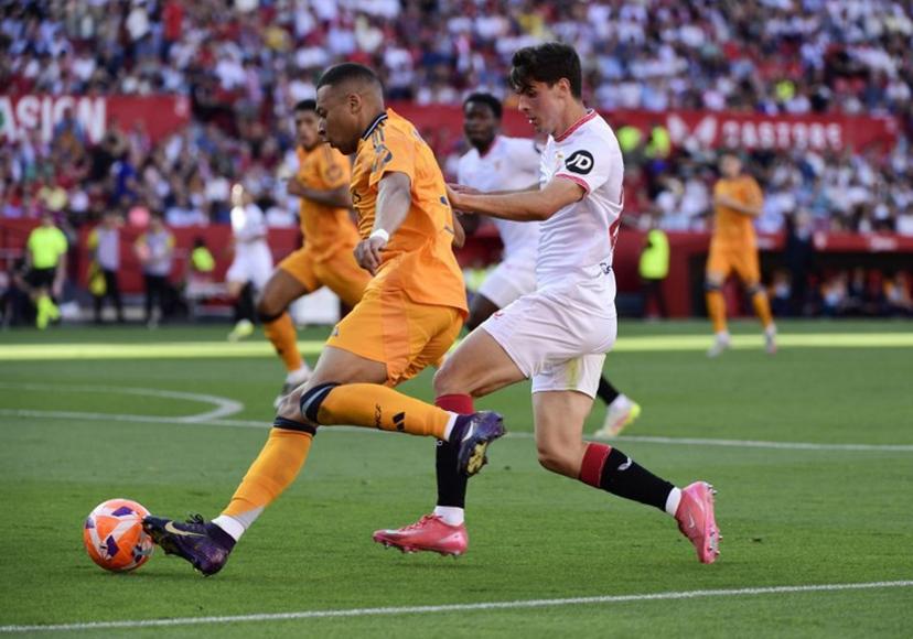 Real Madrid's French forward #09 Kylian Mbappe vies for the ball with Sevilla's Spanish defender #26 Juanlu Sanchez (R) during the Spanish league football match between Sevilla FC and Real Madrid CF at Ramon Sanchez Pizjuan Stadium in Seville on May 18, 2025.  CRISTINA QUICLER / AFP