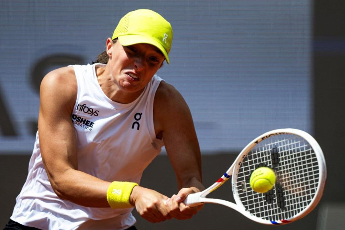 Poland's Iga Swiatek plays a backhand return to US' Danielle Collins during their women's singles match of the WTA Rome Open tennis tournament at Foro Italico in Rome on May 10, 2025.   MARCO BERTORELLO / AFP
