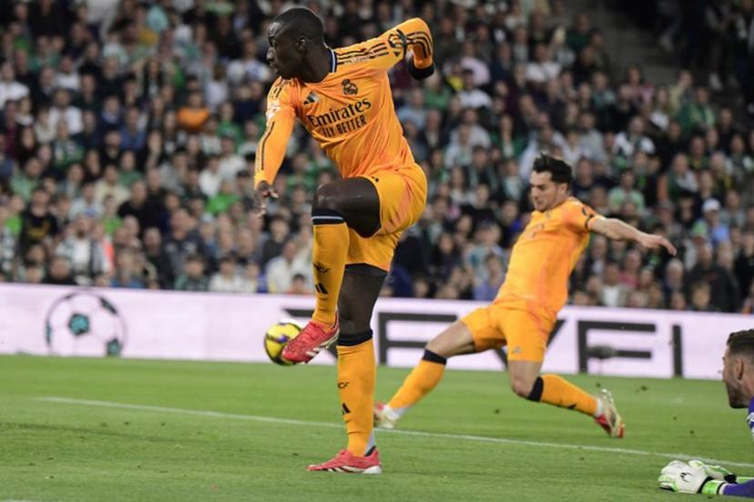 Real Madrid's French defender #23 Ferland Mendy (L) passes the ball to Real Madrid's Moroccan forward #21 Brahim Diaz (R) who scores the opening goal during the Spanish league footbal match between Real Betis and Real Madrid CF at Benito Villamarin Stadium in Seville on March 1, 2025.  CRISTINA QUICLER / AFP