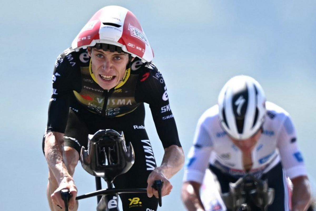 Team Visma - Lease a bike team's Danish rider Jonas Vingegaard cyles past Soudal Quick-Step team's Belgian rider Remco Evenepoel metres from the finish line of the 13th stage of the 112th edition of the Tour de France cycling race, 10.9 km individual time trial between Loudenvielle and Peyragudes, in the Pyrenees mountains of southwestern France, on July 18, 2025.  Loic VENANCE / AFP
