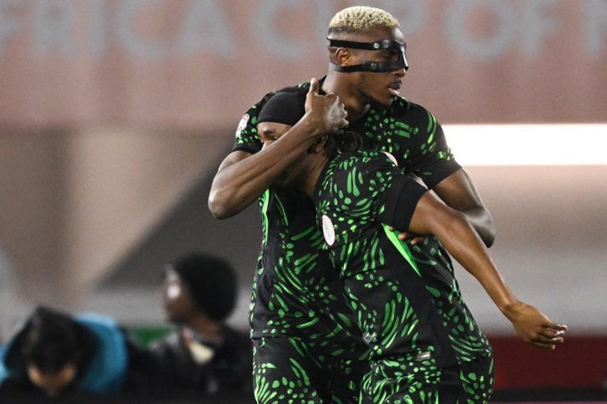 Nigeria's forward #09 Victor Osimhen (L) celebrates scoring the team's third goal with Nigeria's forward #07 Ademola Lookman during the Africa Cup of Nations (CAN) round of 16 football match between Nigeria and Mozambique at the Sports Complex stadium in Fes on January 5, 2026.   SEBASTIEN BOZON / AFP