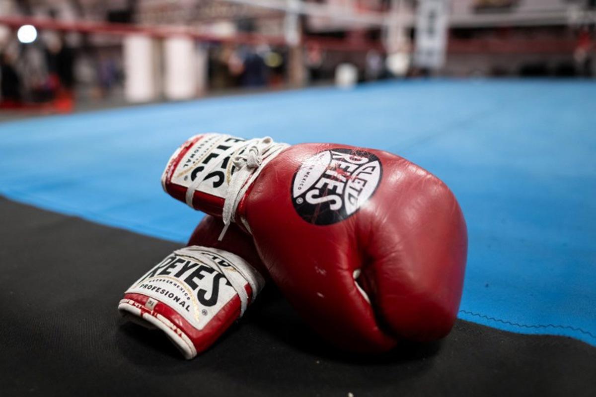 A pair of boxing gloves are seen at the sports and boxing hall at La Busserine neighbourhood in the northern Marseille on January 24, 2025.   In Marseille, former boxers put their experience to the service of young people from the northern neighbourhoods, confronted with violence and drug trafficking, hoping to "save a few". Miguel MEDINA / AFP