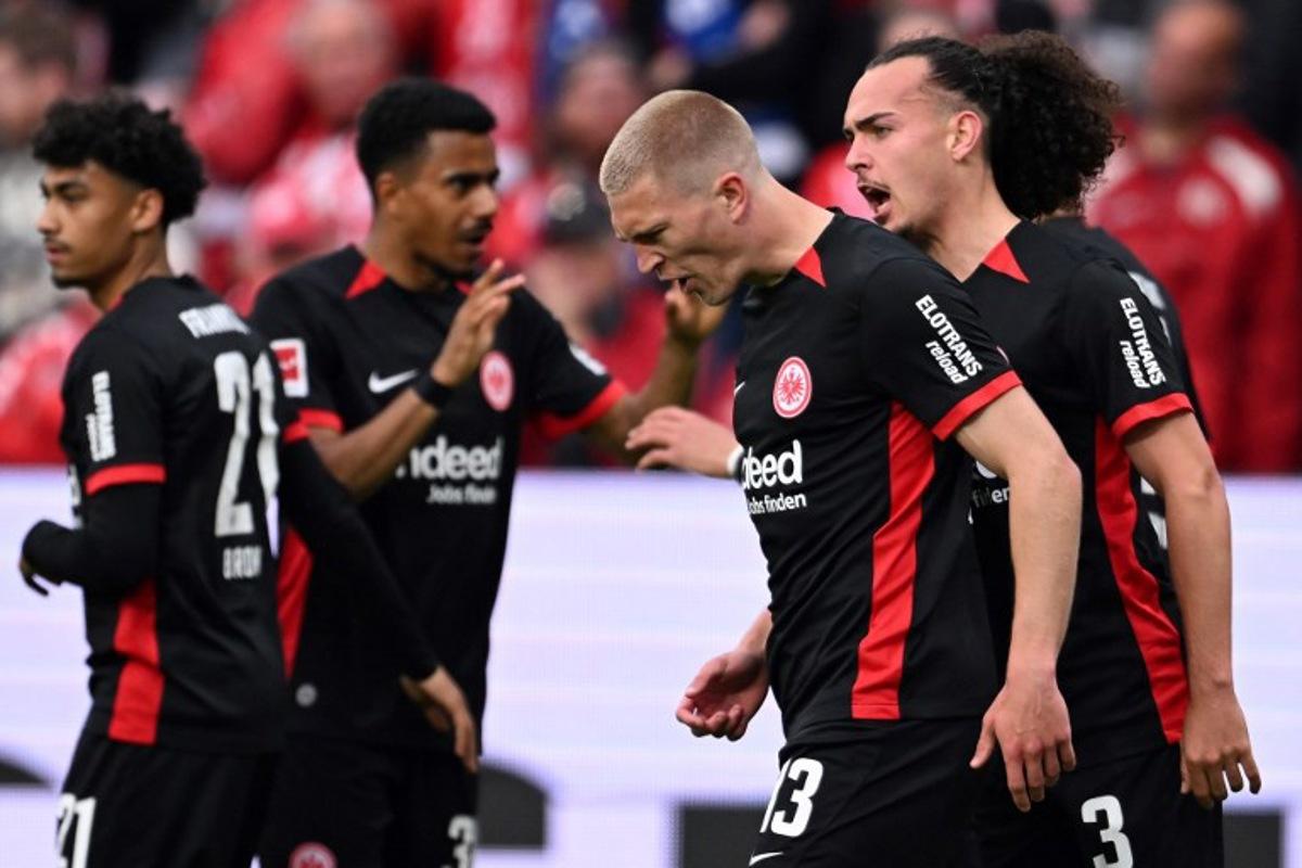 Frankfurt's Danish defender #13 Rasmus Kristensen (C) celebrates scoring the opening goal with his teammates during the German first division Bundesliga football match between 1 FSV Mainz 05 and Eintracht Frankfurt in Mainz, western Germany on May 4, 2025. Kirill KUDRYAVTSEV / AFP