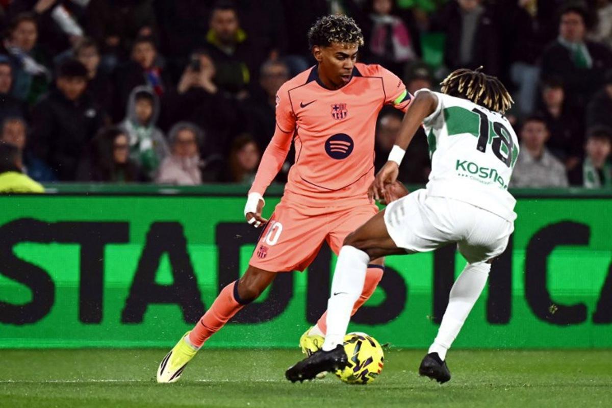 Barcelona's Spanish forward #10 Lamine Yamal and Elche's Spanish defender #18 John Donald fight for the ball during the Spanish league football match between Elche CF and FC Barcelona at thge Martinez Valero stadium in Elche on January 31, 2026.  JOSE JORDAN / AFP