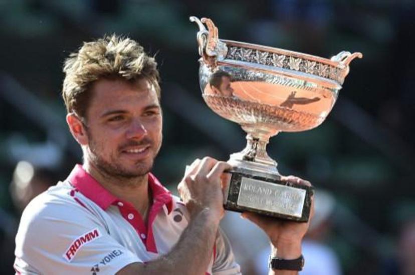 Switzerland's Stanislas Wawrinka celebrates with the trophy following his victory over Serbia's Novak Djokovic at the end of their men's final match of the Roland Garros 2015 French Tennis Open in Paris on June 7, 2015. AFP PHOTO / DOMINIQUE FAGET