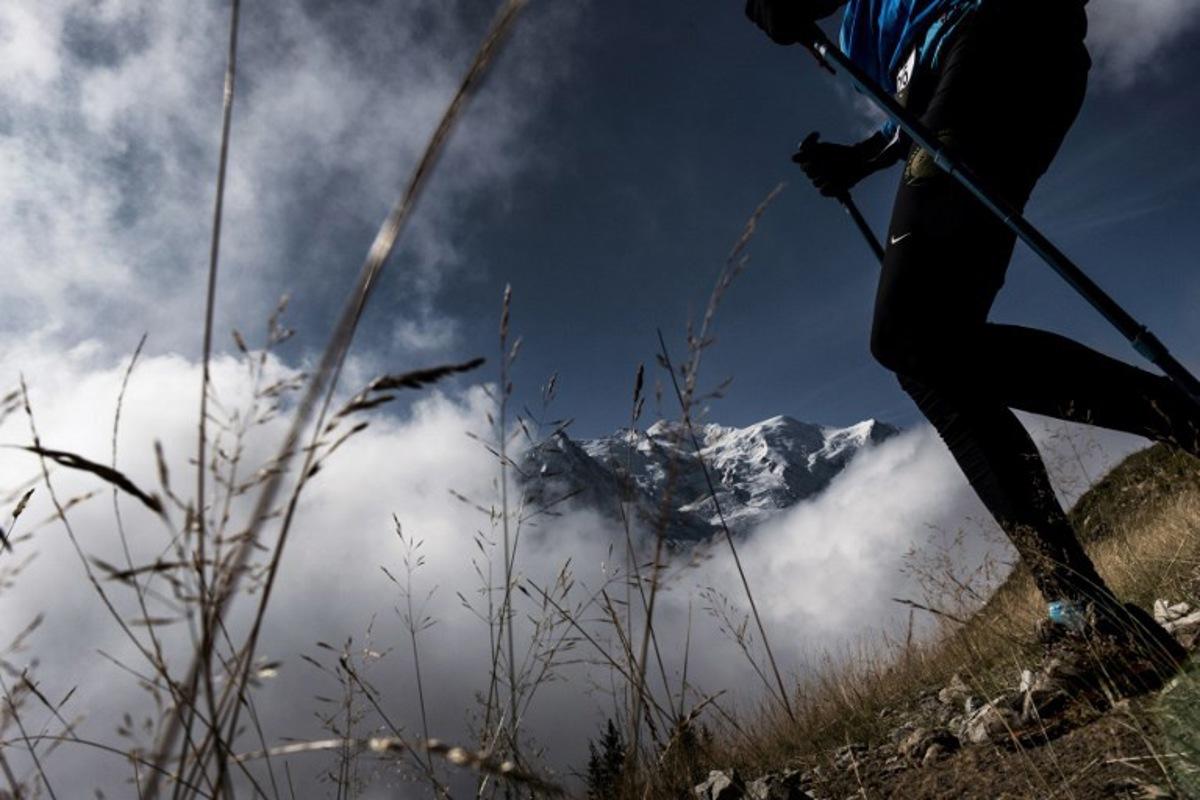 An ultra-trailer walks past the Mount Blanc (Mont-Blanc) in La Flegere path (col de la Flegere) on September 3, 2017 near Chamonix, as he competes during the 15th edition of the Mount Blanc Ultra Trail (UTMB), a 170 km race around the Mont Blanc crossing France, Italy and Switzerland. The 15th Ultra-Trail du Mont-Blanc (UTMB) is a mountain ultramarathon with numerous passages in high altitude (>2500m) and in difficult weather conditions (night, wind, cold, rain or snow). It takes place once a year in the Alps, across France, Italy and Switzerland. JEFF PACHOUD / AFP