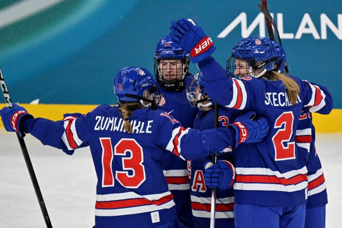 USA's defender #03 Cayla Barnes (unseen) celebrates with teammates after scoring her team's first goal during the women's play-off semi-final ice hockey match between USA and Sweden at the Milano Santagiulia Ice Hockey Arena during the Milano Cortina 2026 Winter Olympic Games in Milan, on February 16, 2026.  Alexander NEMENOV / AFP