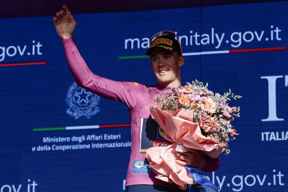 Lidl-Trek's Danish rider Mads Pedersen, wearing the overall leader's pink jersey (Maglia Rosa), celebrates on the podium after the 4th stage of the 108th Giro d'Italia cycling race 189kms from Alberobello to Lecce on May 13, 2025.  Luca Bettini / AFP