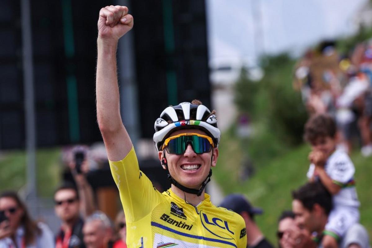 UAE Team Emirates XRG's Slovenian rider Tadej Pogačar wearing the overall leader's yellow jersey celebrates as he crosses the finish line to win the 7th stage of the 77th edition of the Criterium du Dauphine cycling race, 131,6 km between Grand-Aigueblanche and Valmeinier, on June 14, 2025.  Anne-Christine POUJOULAT / AFP