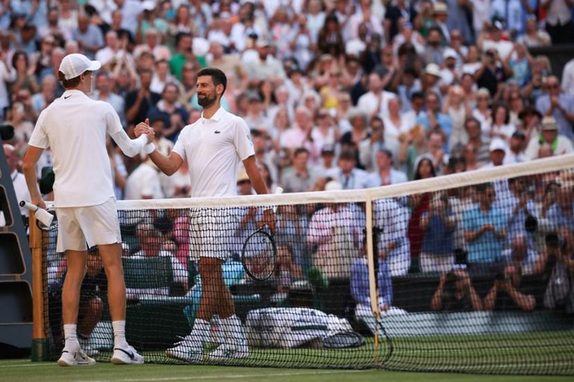 Italy's Jannik Sinner (L) shakes hands with Serbia's Novak Djokovic after winning their men's singles semi-final tennis match on the twelfth day of the 2025 Wimbledon Championships at The All England Lawn Tennis and Croquet Club in Wimbledon, southwest London, on July 11, 2025.  HENRY NICHOLLS / AFP