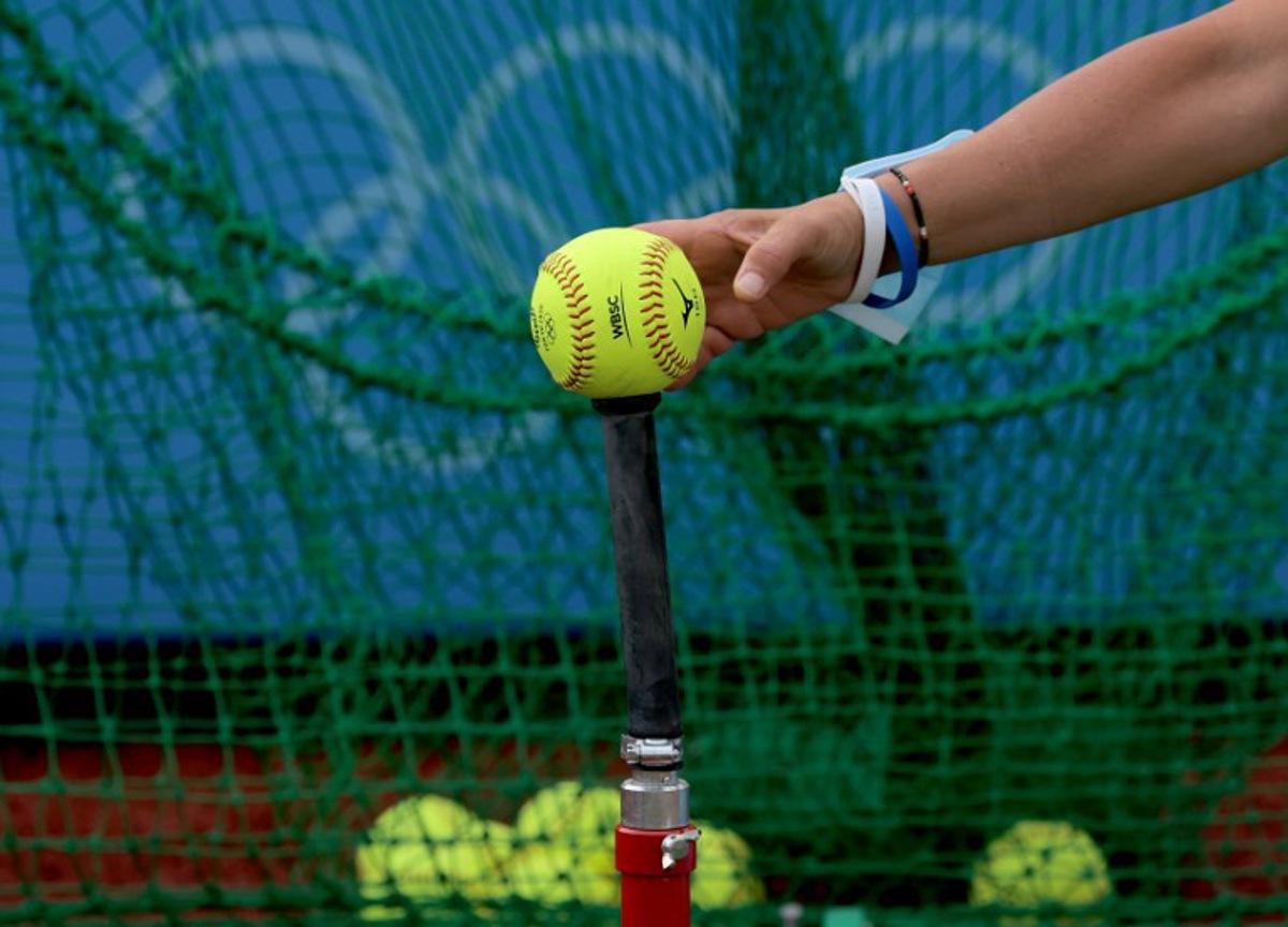 Unidentified Italy's softball player puts a ball onto the tee at the training area prior to the Tokyo 2020 Olympic Games softball opening round game between Italy and Australia at Fukushima Azuma Baseball Stadium in Fukushima, Japan, on July 22, 2021.  KAZUHIRO FUJIHARA / AFP