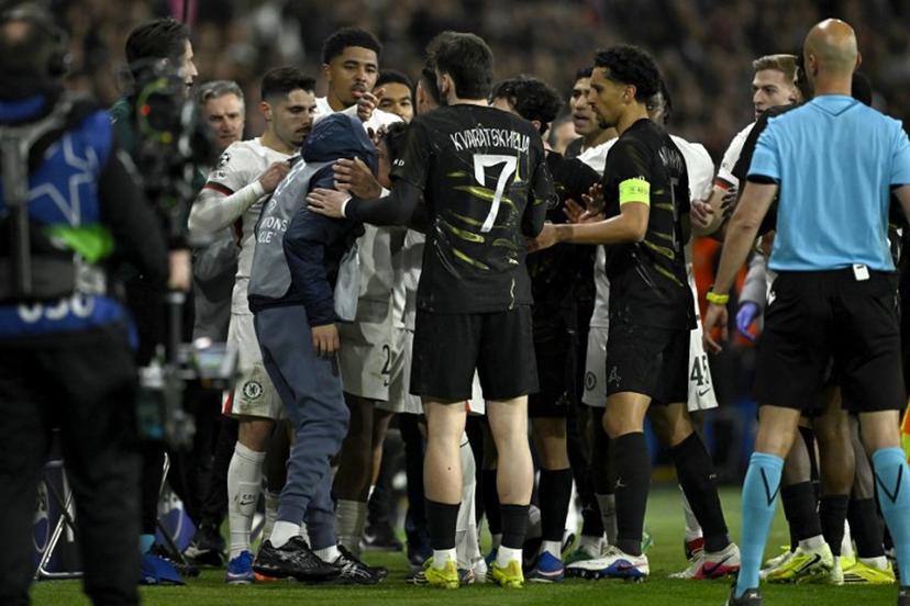 Chelsea's Portuguese forward #07 Pedro Neto (L) tends to a ballboy after he pushed him during the UEFA Champions League round of 16 first leg football match between Paris Saint-Germain (PSG) and Chelsea at the Parc des Princes stadium in Paris on March 11, 2026.   JULIEN DE ROSA / AFP