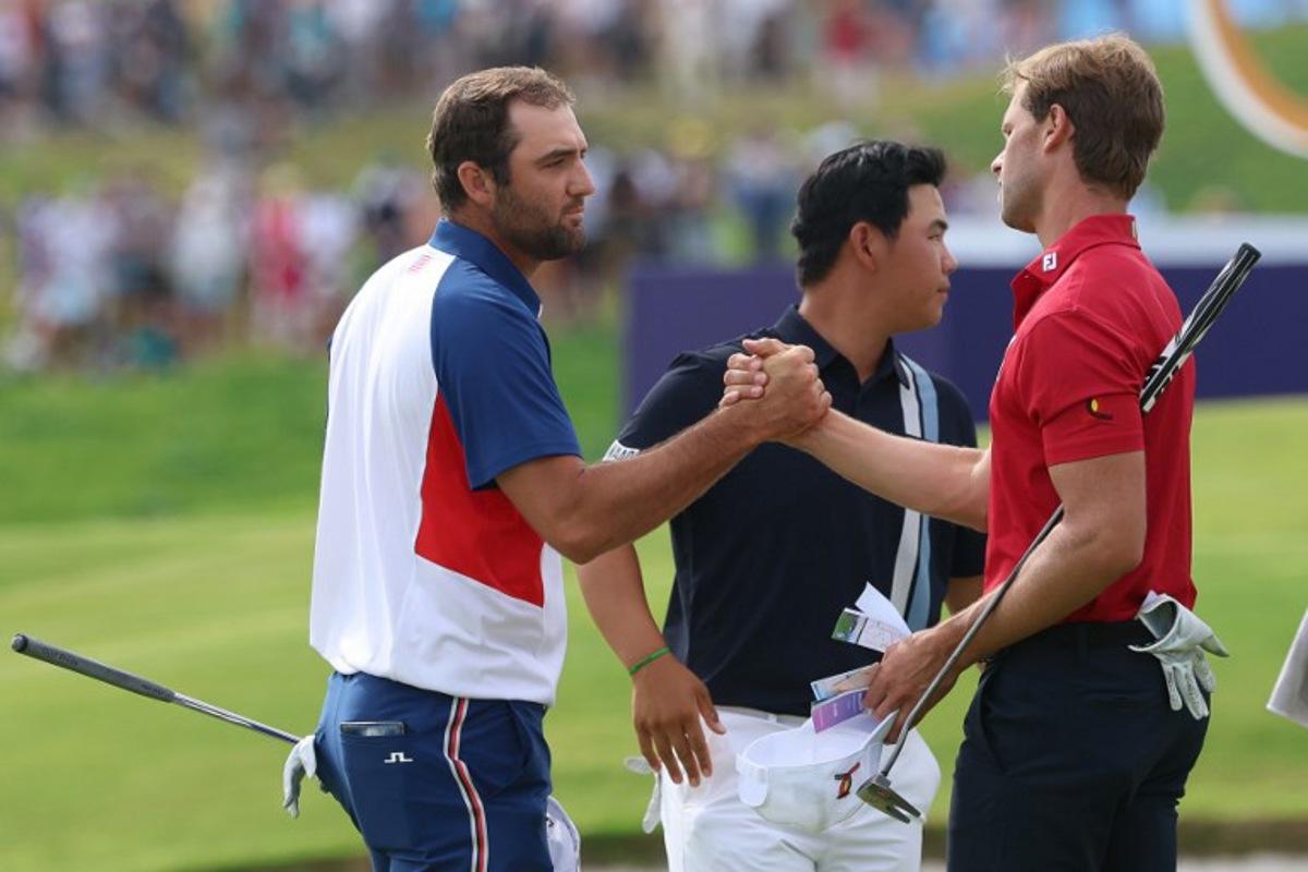 (From L) US' Scottie Scheffler, South Korea's Kim Jooh-yung and Belgium's Thomas Detry greet each other after completing the course in round 4 of the men's golf individual stroke play of the Paris 2024 Olympic Games at Le Golf National in Guyancourt, south-west of Paris on August 4, 2024.   Emmanuel DUNAND / AFP