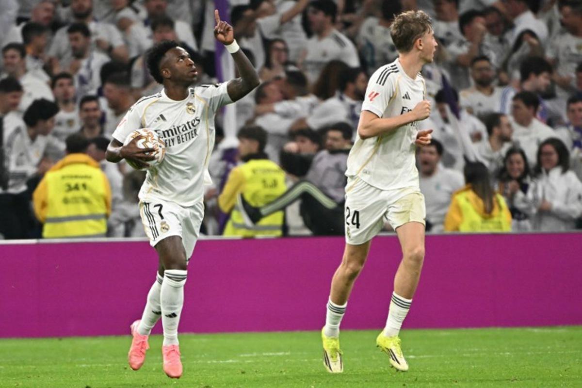 Real Madrid's Brazilian forward #07 Vinicius Junior (L) celebrates scoring his team's first goal during the Spanish league football match between Real Madrid CF and Club Atletico de Madrid at Santiago Bernabeu Stadium in Madrid on March 22, 2026.  Javier SORIANO / AFP