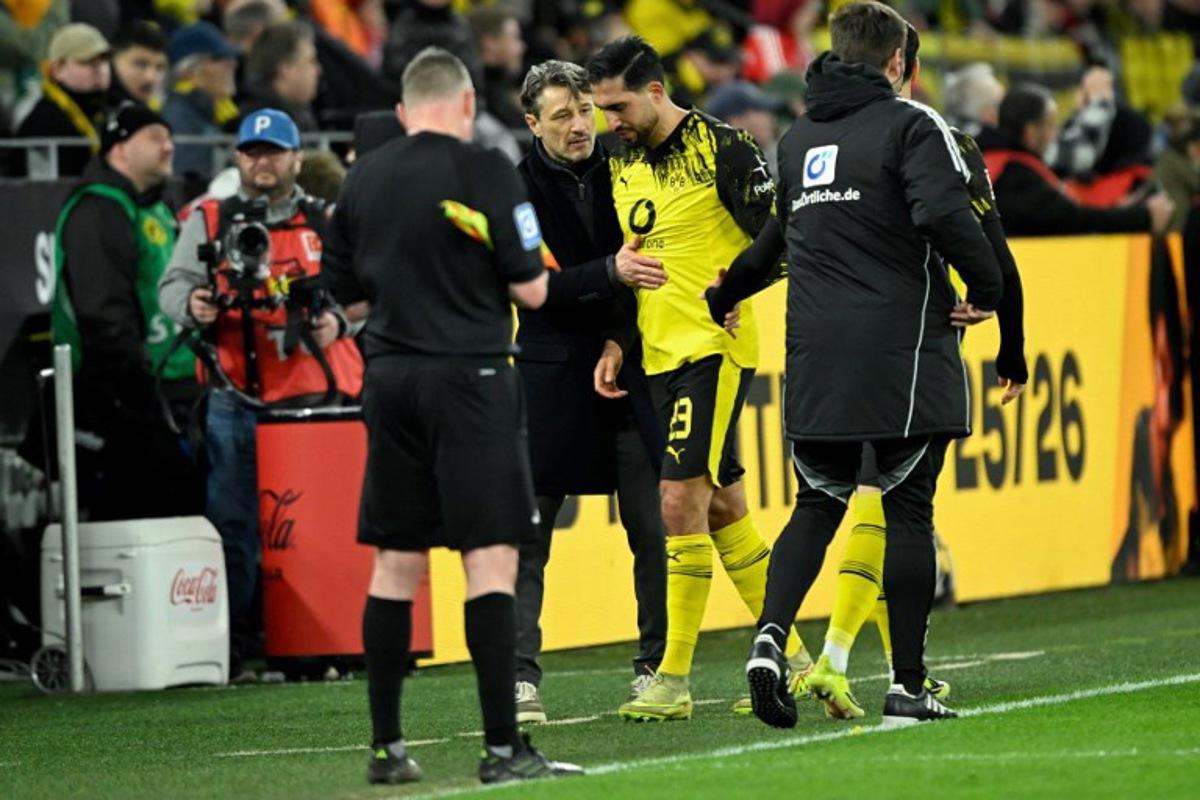 Dortmund's German midfielder #23 Emre Can (C) is consoled by Dortmund's Croatian head coach Niko Kovac as he goes off after sustaining an injury during the German first division Bundesliga football match between BVB Borussia Dortmund and FC Bayern Munich in Dortmund, western Germany, on February 28, 2026.  INA FASSBENDER / AFP