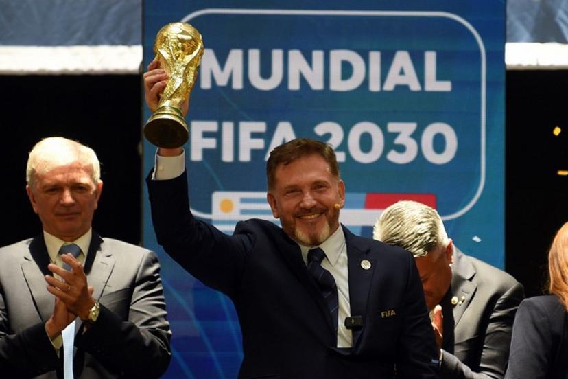 CONMEBOL President Paraguayan Alejandro Dominguez holds a replica of the FIFA World Cup as he celebrates the ratification of Argentina, Paraguay, and Uruguay as host countries of the FIFA 2030 World Cup during the FIFA virtual Congress in Luque, Paraguay, on December 11, 2024. A virtual Congress of world football's governing body confirmed that Morocco, Spain and Portugal will be joint hosts of the 2030 World Cup, which will also see three games played in South America. The 2030 tournament will mark a century since the first World Cup was held in Uruguay, and as a result the unrivalled joint bid by Morocco, Spain and Portugal will also see the South American nation handed one game along with Argentina and Paraguay.  DANIEL DUARTE / AFP
