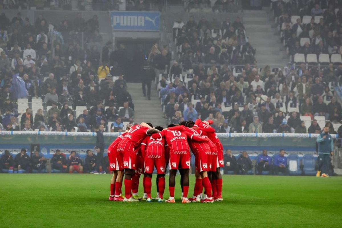 Montpellier's players gather in a huddle ahead of the French L1 football match between Olympique de Marseille (OM) and Montpellier HSC at Stade Velodrome in Marseille, southern France on April 19, 2025.  CLEMENT MAHOUDEAU / AFP