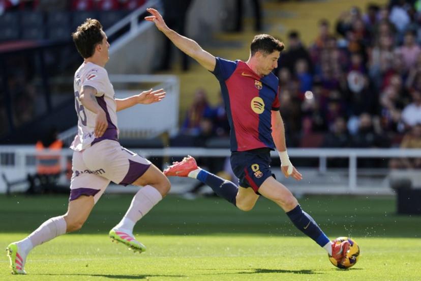 Barcelona's Polish forward #09 Robert Lewandowski (R) shoots challenged by Girona's Dutch midfielder #06 Donny Van de Beek during the Spanish league football match between FC Barcelona and Girona FC at the Estadi Olimpic Lluis Companys in Barcelona on March 30, 2025.  LLUIS GENE / AFP