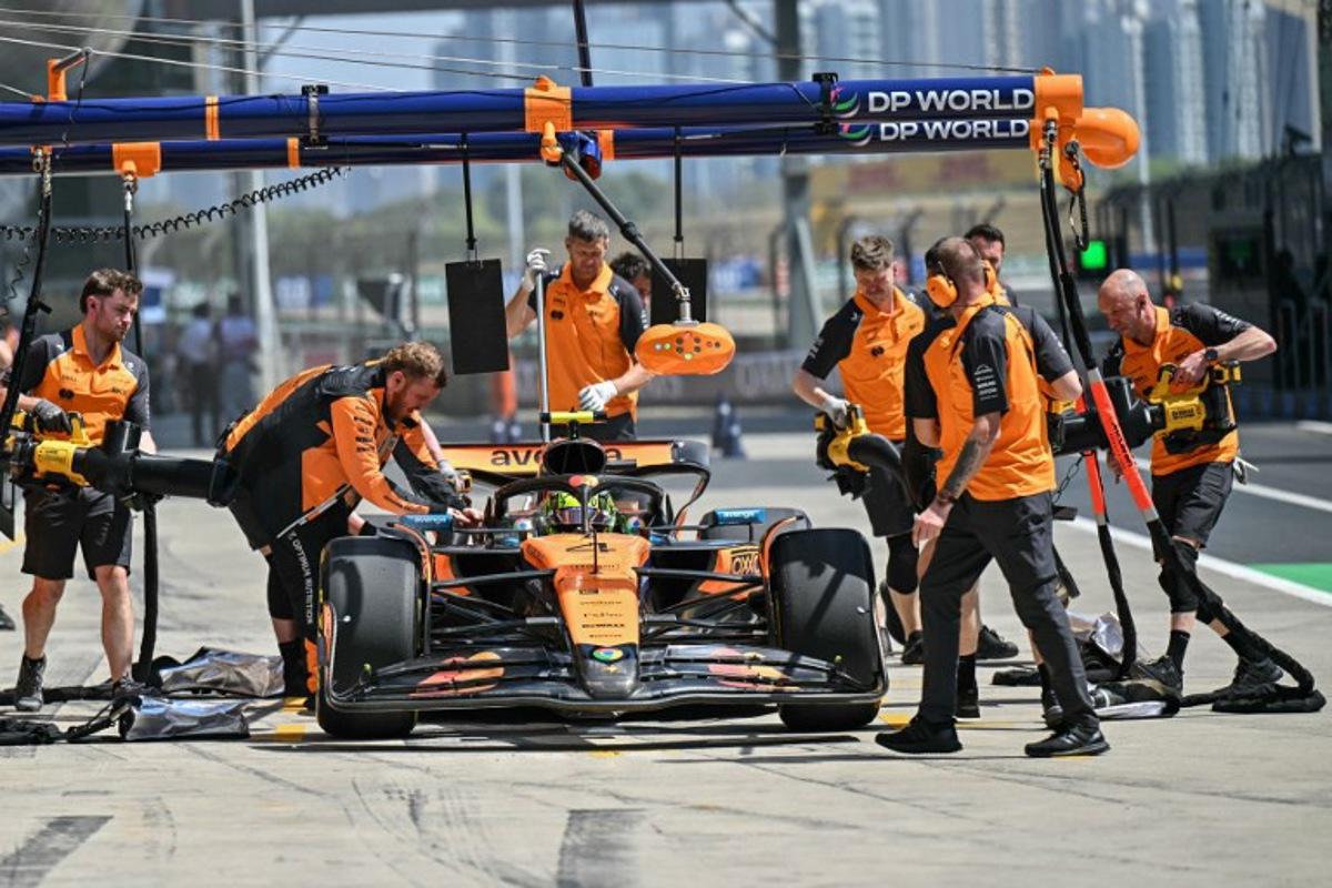 Mechanics work on the car of McLaren's British driver Lando Norris in the pits during the first practice session of the Formula One Chinese Grand Prix at the Shanghai International Circuit in Shanghai on March 21, 2025.  HECTOR RETAMAL / AFP
