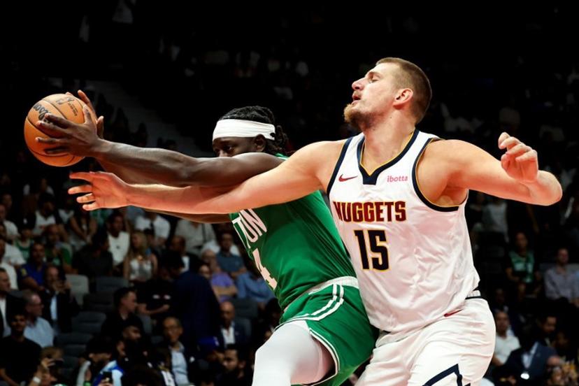 Boston Celtics' guard #04 Jrue Holiday fights for the ball with Denver Nuggets' center #15 Nikola Jokic during the NBA Preseason game between the Boston Celtics and the Denver Nuggets at the Etihad Arena in Abu Dhabi on October 6, 2024.  Fadel Senna / AFP