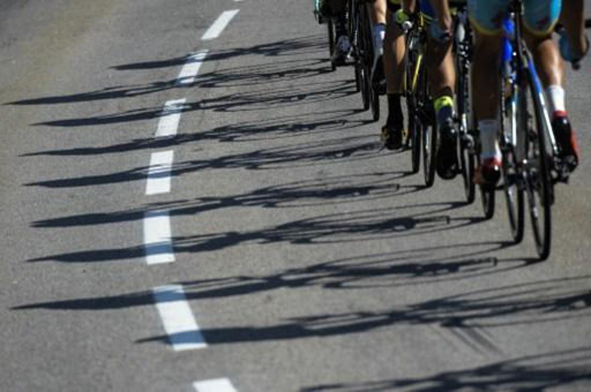 Shadows of wheels are pictured during the 186,5 km eighteenth stage of the 102nd edition of the Tour de France cycling race on July 23, 2015, between Gap and Saint-Jean-de-Maurienne, French Alps.  AFP PHOTO / LIONEL BONAVENTURE