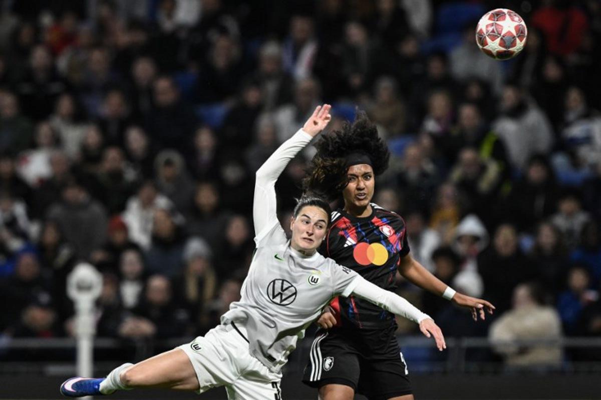 Lyon's US midfielder #20 Lily Yohannes (R) fights for the ball with VfL Wolfsburg's Dutch defender #03 Caitlin Dijkstra (L) during the UEFA Women's Champions League quarter final second leg football match between OL Lyonnes (Lyon) and VfL Wolfsburg at the Groupama stadium in Decines-Charpieu, central-eastern France, on April 2, 2026.  JEFF PACHOUD / AFP