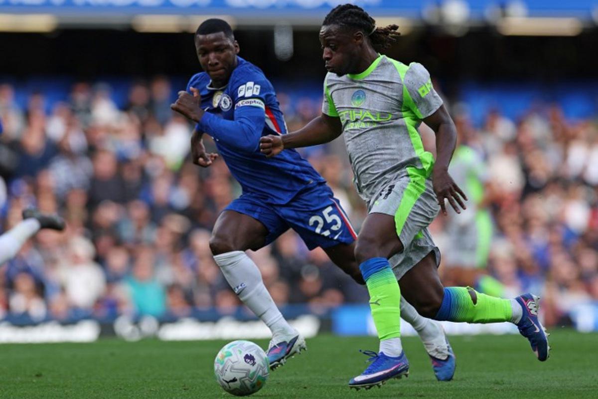 Chelsea's Ecuadorian midfielder #25 Moises Caicedo (L) challenges Manchester City's Belgian midfielder #11 Jeremy Doku during the English Premier League football match between Chelsea and Manchester City at Stamford Bridge in London on April 12, 2026.  Adrian Dennis / AFP