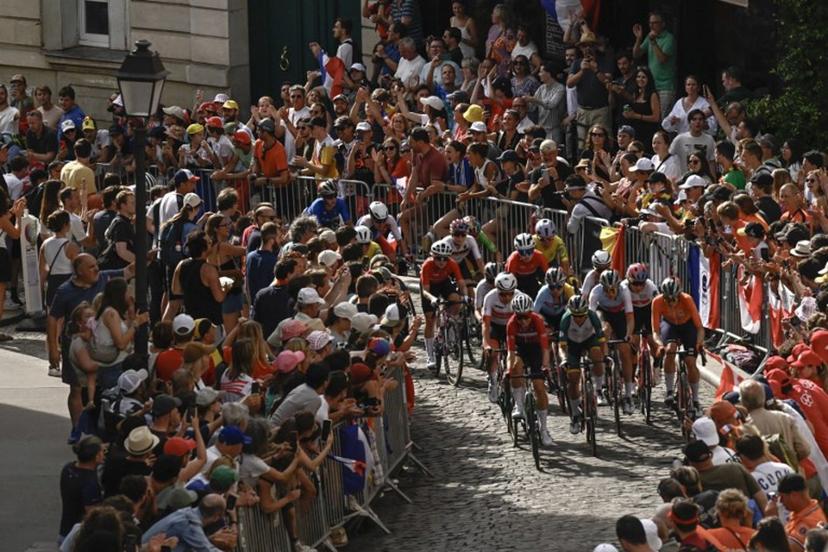 The pack of riders (peloton) cycles in the ascent of Rue Lepic on the Butte de Montmartre during the women's cycling road race during the Paris 2024 Olympic Games in Paris, on August 4, 2024.  JULIEN DE ROSA / AFP