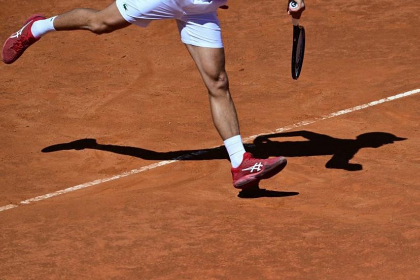 Serbia's Novak Djokovic casts a shadow on the clay court as he serves to Chile's Alejandro Tabilo during the Men's ATP Rome Open tennis tournament at Foro Italico in Rome on May 12, 2024.   Tiziana FABI / AFP