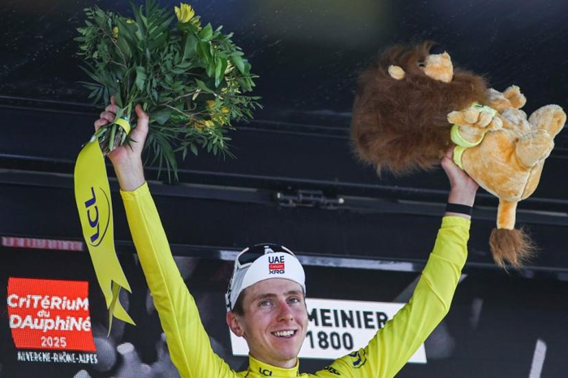 UAE Team Emirates XRG's Slovenian rider Tadej Pogačar celebrates wearing the overall leader's yellow jersey on the podium of the 7th stage of the 77th edition of the Criterium du Dauphine cycling race, 131,6 km between Grand-Aigueblanche and Valmeinier, on June 14, 2025.  Anne-Christine POUJOULAT / AFP