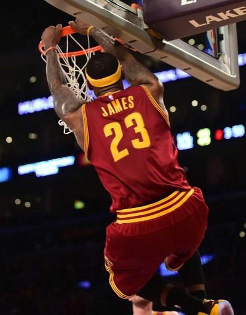 LeBron James of the Cleveland Cavaliers hangs onto the rim after failing to score off a slam dunk as the ball bounced off the rim against the Los Angeles Lakers during their NBA game at Staples Center in Los Angeles, California on January 15, 2014.  AFP PHOTO/Frederic J. BROWN