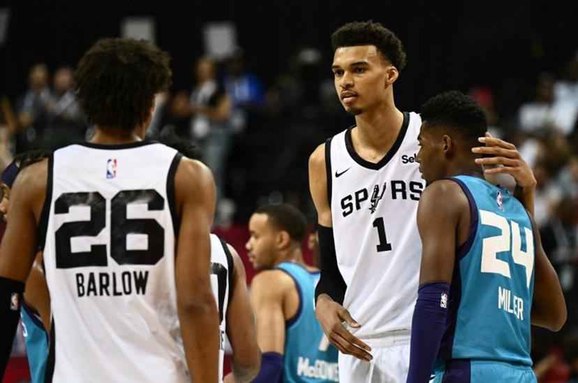 San Antonio Spurs' Victor Wembanyama (C) stands with Charlotte Hornets' Brandon Miller (R) and San Antonio Spurs' Dominick Barlow (L) at the end of the NBA Summer League game between the San Antonio Spurs and Charlotte Hornets, at the Thomas and Mack Center in Las Vegas, Nevada, on July 7, 2023.  Patrick T. Fallon / AFP