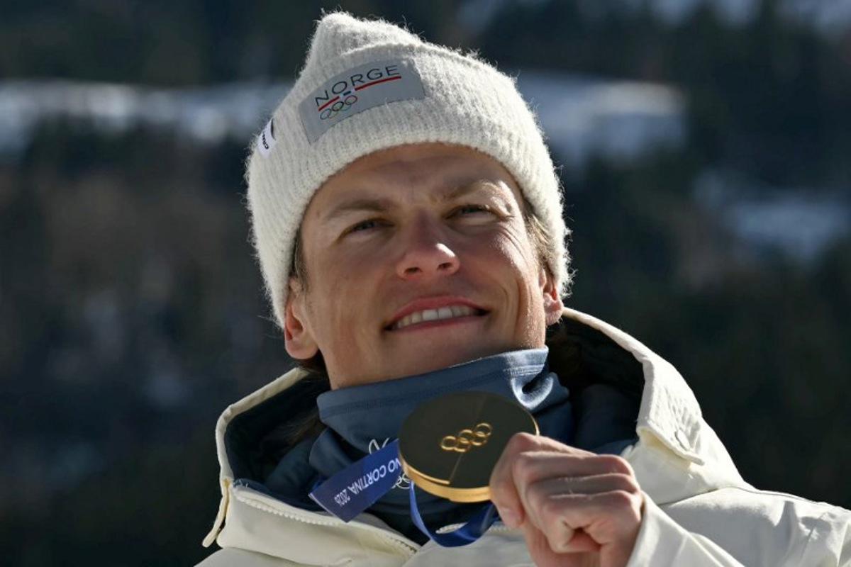 Gold medallist Norway's Johannes Hoesflot Klaebo celebrates on the podium for the men's team cross country free sprint final event of the Milano Cortina 2026 Winter Olympic Games at Tesero Cross-Country Skiing Stadium in Lago di Tesero (Val di Fiemme), on February 18, 2026.  Javier SORIANO / AFP