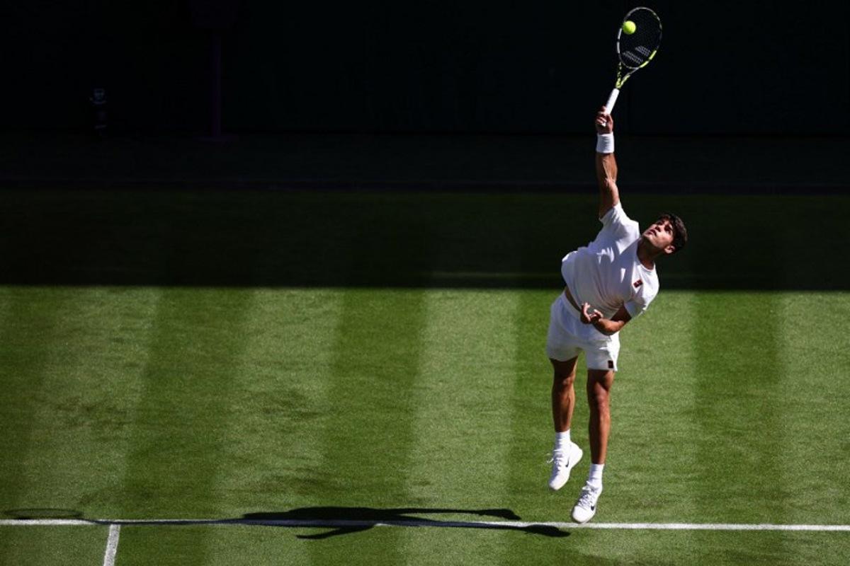 Spain's Carlos Alcaraz serves to Italy's Fabio Fognini during their men's singles first round tennis match on the first day of the 2025 Wimbledon Championships at The All England Lawn Tennis and Croquet Club in Wimbledon, southwest London, on June 30, 2025.  HENRY NICHOLLS / AFP